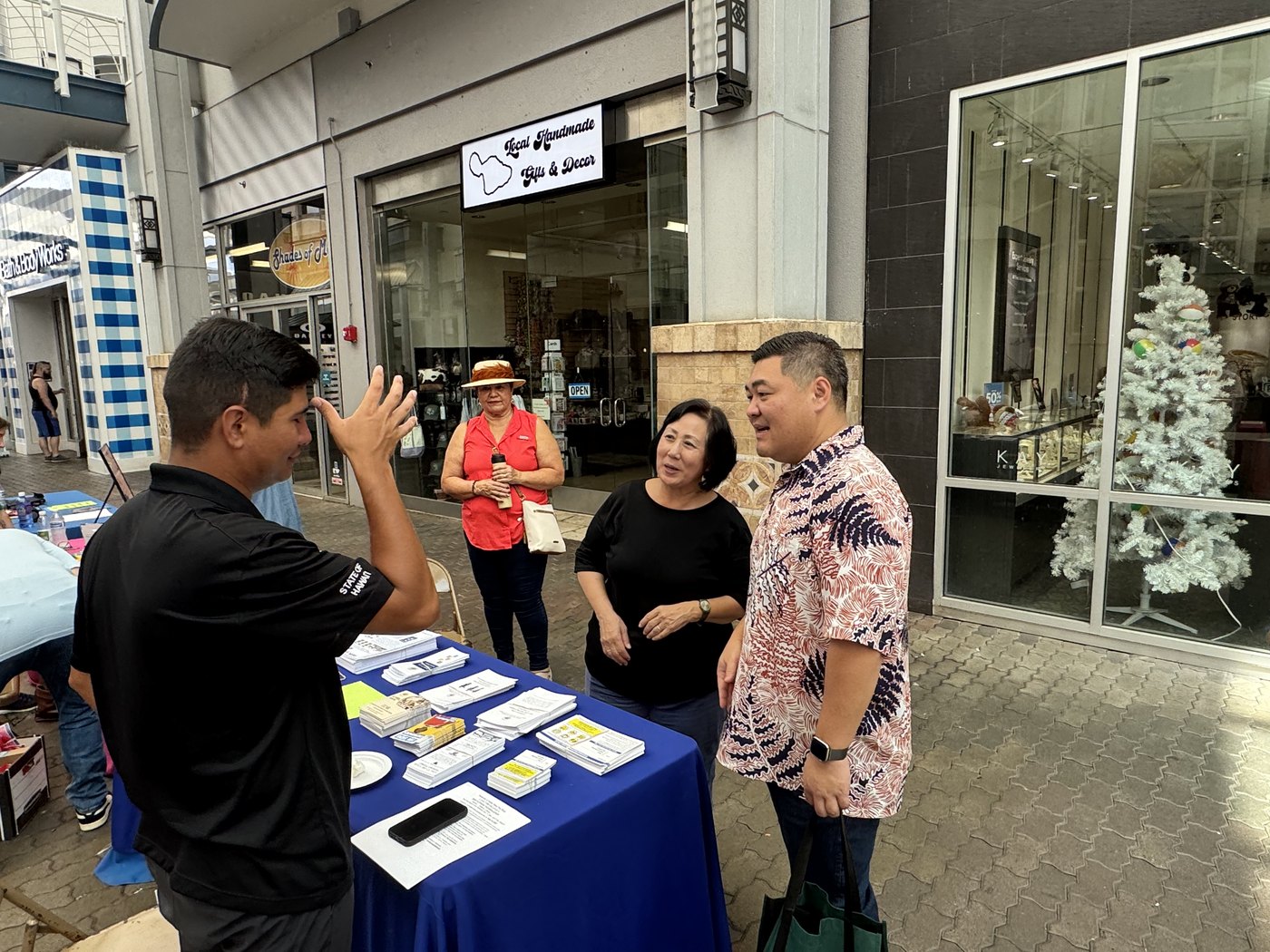 Tyson Miyake speaking with volunteers at a community table